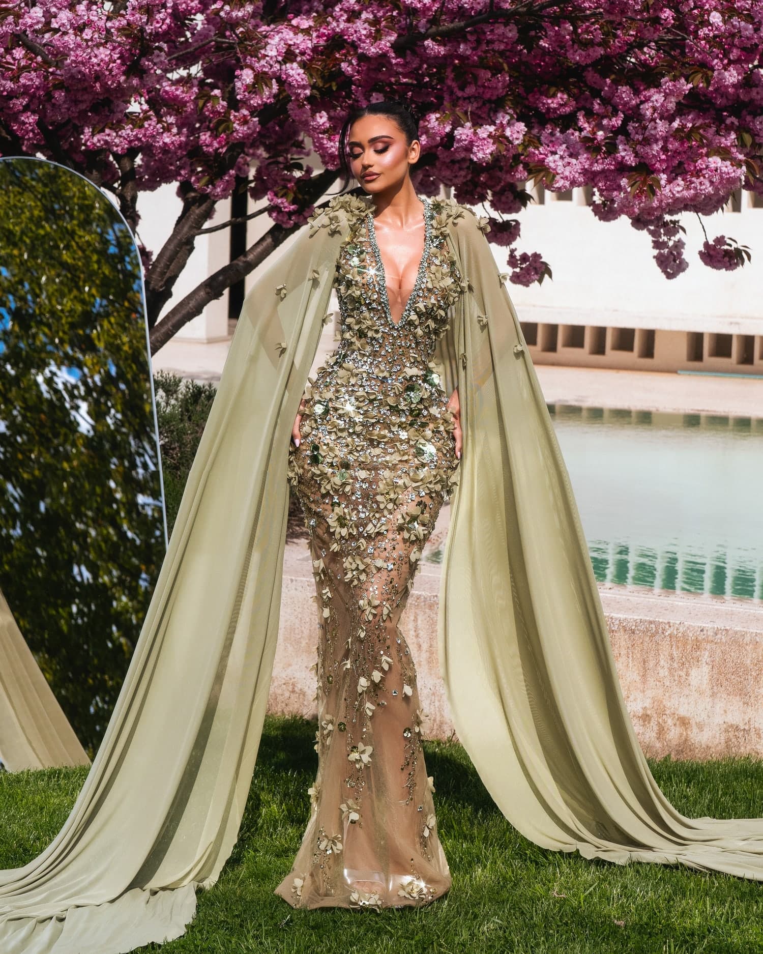 SELINE — full sage mermaid silhouette with chiffon cape sleeves against cherry blossoms