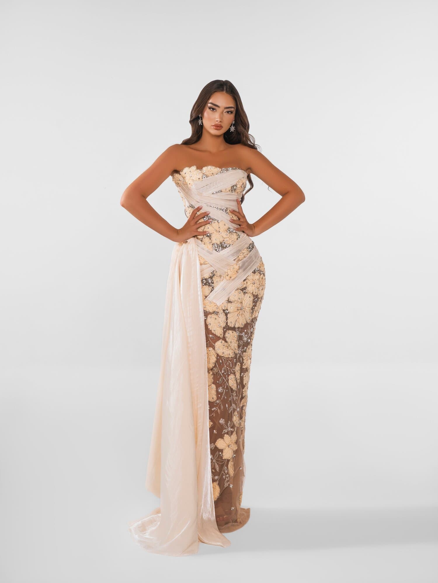 CREMELLE — Strapless cream column wrapped in a draped chiffon sash that falls into a train