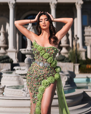 Elegant green dress with a deep slit and floral details.