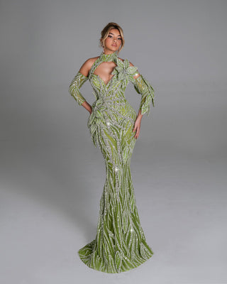 Elegant green gown with intricate crystal patterns and a large floral accent on the bodice.