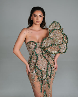 Elegant nude gown with green and crystal embellishments.