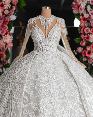 Close-up of the Amber Bridal Dress, showcasing intricate floral detailing on a fitted bodice and soft, elegant layers.