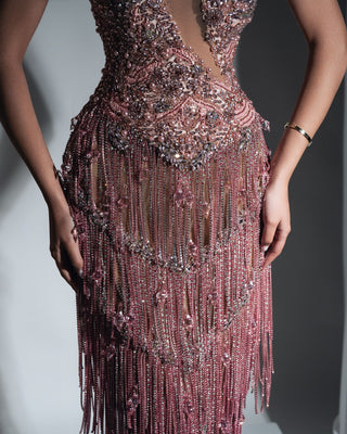Close-up view of the intricate tassel and crystal details on the light pink dress.