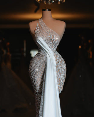 Elegant one-shoulder dress with shimmering crystal embellishments and a flowing white drape.