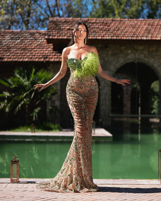 A luxurious green dress adorned with shimmering crystals and feather details for a glamorous look.