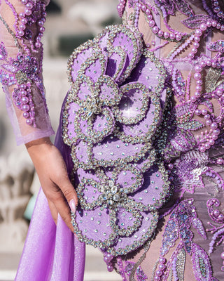 Model posing in a lavender dress with dramatic train.