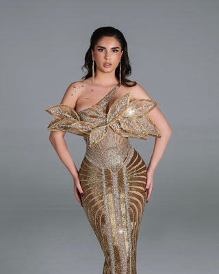 Brianna's golden dress featuring a sculpted leaves embellishment and sleek silhouette.