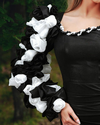 Close-up of floral embellishments on sleeve of one shoulder black dress