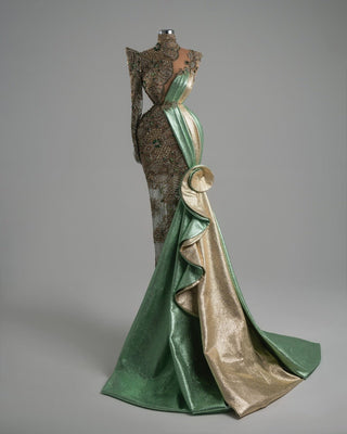 A fitted evening dress featuring gold and green beadwork, with a voluminous sculptural skirt.