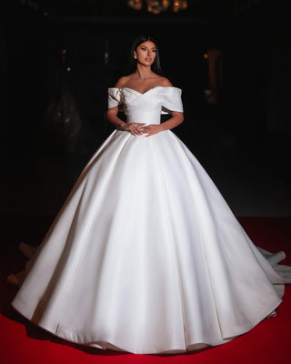 
A luxurious off-shoulder satin ball gown bridal dress with a timeless and elegant design.