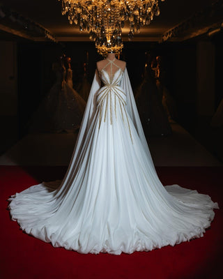 Elegant white bridal gown with flowing drapes and a structured silhouette.