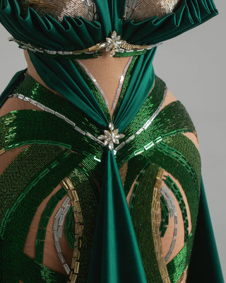 Dramatic emerald dress with intricate crystal accents and flowing skirt.