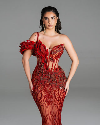 A glamorous red dress with floral appliqués, an asymmetric neckline, and intricate embroidery.