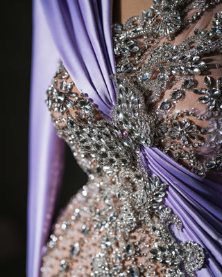 Sophisticated lavender evening gown with sparkling crystals and modern one-shoulder draping.