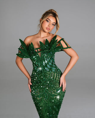 Emerald off-shoulder gown with crystal embellishments and leaf-inspired design.