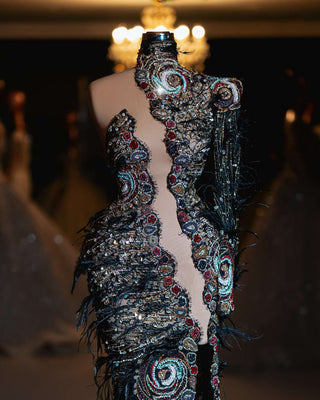 Intricate couture gown with bold beadwork and black feathers.