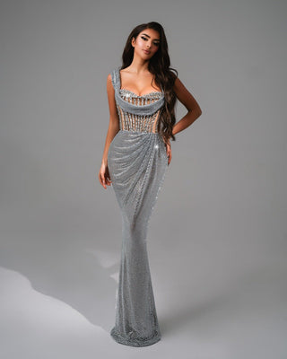 A shimmering silver dress with a corset bodice and cascading stone embellishments.