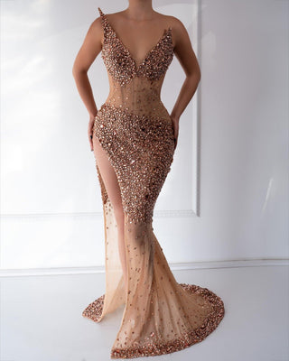 A shimmering rose gold mermaid dress with crystal embellishments and a thigh-high slit.