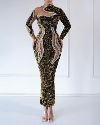 
A gold sequined gown with crystal embellishments and sheer panel details.