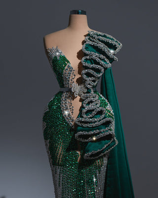 Emerald green gown with silver crystal details and a dramatic velvet cape.