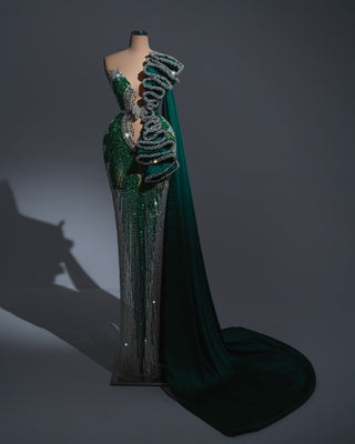 Asymmetrical green dress featuring sculpted ruffles and glittering beadwork.