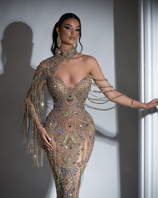 Stunning gold dress adorned with crystals and tassels, featuring a high neck and one-shoulder style
