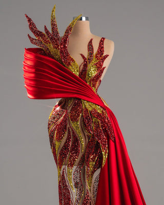 Fiery red one-shoulder gown with sequins and a flowing train.