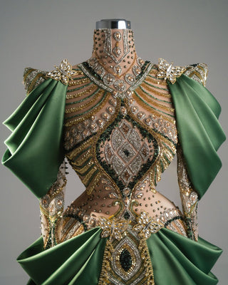 Fitted nude gown with emerald satin details, decorated with crystals, beads, and a sweeping satin train.