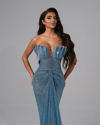 Shimmering blue gown with a ruched waist and sleek fit.