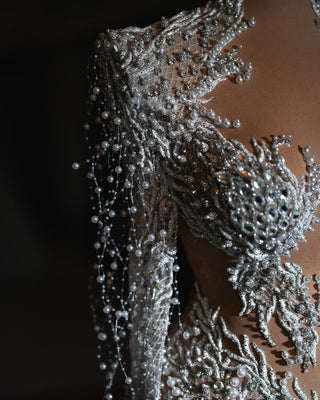 Close-up view of the Lenie Bridal Dress, highlighting the shimmering pearls that enhance the dress's delicate satin fabric.