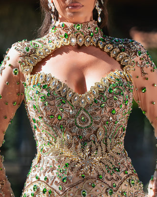 Close-up of the Makena nude gown, featuring intricate green crystals delicately sewn onto the fabric, creating a glamorous effect.