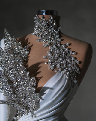 Elegant one-shoulder gown adorned with crystals and pearls for a regal bridal look.