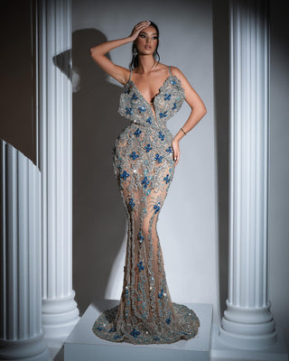 Elegant long silver dress with thin straps and chest cut-out, adorned with silver and blue crystals