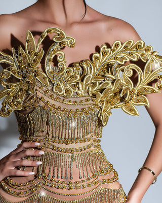 Close-up of gold dress detailing, showing tassels and embedded stones