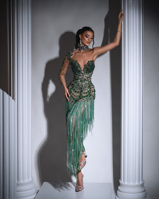 Green dress with one-shoulder design and tassels and beads.