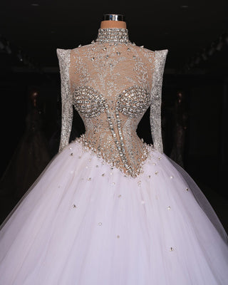 Handmade bridal gown with long sleeves, crystal embellishments, and a sweeping train.