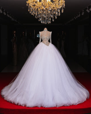 Elegant wedding dress featuring sheer tulle sleeves and sparkling crystal details.