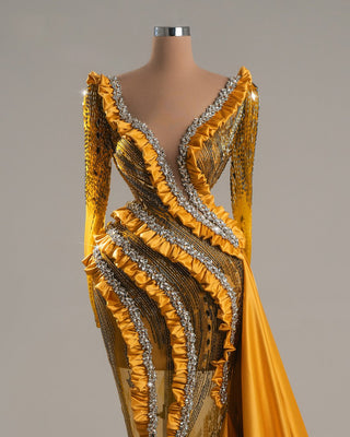 Yellow long dress with long sleeves, open chest, and crystal embellishments.