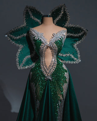 Emerald green gown with crystal embellishments and dramatic 3D petal shoulders.